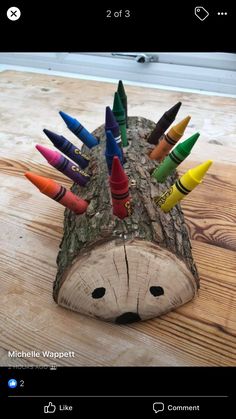 an animal made out of crayons sitting on top of a wooden table