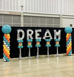 balloons and streamers are arranged in the shape of letters that spell out'dream '