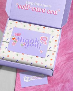 two boxes with thank you stickers on them sitting next to each other in pink and purple