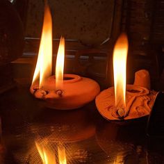 three lit candles sitting on top of a table