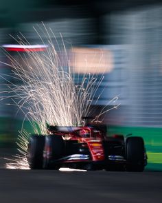 a red bull racing car with sparks in the air