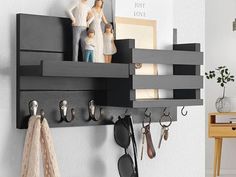 a wall mounted shelf with key hooks and other items hanging from it's sides