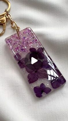 a glass keychain with purple flowers on it