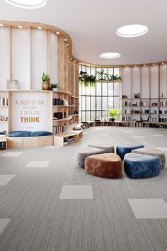 an empty library with bookshelves and round seatings on the floor in front of large windows