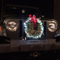 a christmas wreath on the front of a jeep