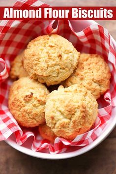 four biscuits in a red and white checkered bowl with the words almond flour biscuits