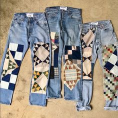 four pairs of jeans with different patchwork designs on them, all lined up together