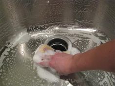 a person is washing their hands in the sink with soap and water on top of it