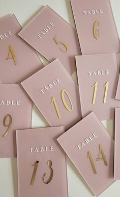 pink table numbers with gold foil on them