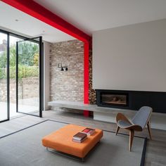 a modern living room with an orange ottoman