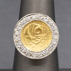 "Chinese 5 Yuan Panda Coin Ring with Diamond Bezel in 14k Yellow Gold This fun piece is full of luck and luxe!  The ring features a 5 yuan Panda coin, 1/20oz of .999 gold.  The coin is bezel set and surrounded by a frame of round prong set diamonds.  The diamonds measure 1.5 to 2.0mm, there are 21 of them leading to a calculated total weight of approximately 0.30cttw.  The diamonds are H/I color and average I1 clarity with no eye visible inclusions.  The coin stands a bit off of the finger with Gold Coin-shaped Anniversary Ring, Gold Coin-shaped Ring For Anniversary, Ceremonial Yellow Gold Coin Jewelry, Gold Coin Ring Vintage Panda, Classic Collectible Coin Rings, Coin Stand, Coin Ring, Ring With Diamond, Bezel Diamond