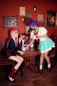 two women sitting at a table with cups in their hands