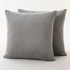 two gray pillows sitting next to each other