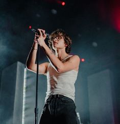 a young man holding a microphone on stage