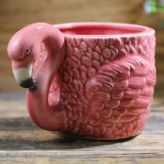 a pink flamingo mug sitting on top of a wooden table