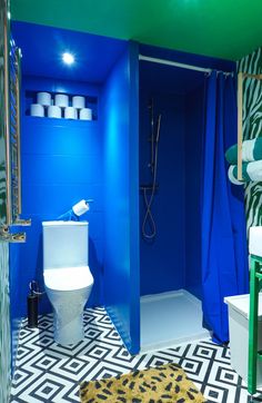 a bathroom with blue walls and black and white flooring is pictured in this image