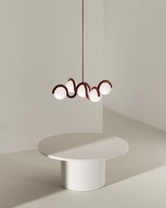 a white table with three lights hanging from it's center and one light on top