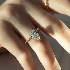 a woman's hand with a diamond ring on it