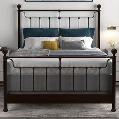 a bedroom with a metal bed frame and blue pillows on the headboard, along with two nightstands