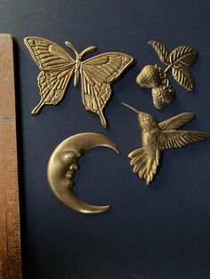 three metal butterflies and a crescent moon on a blue background