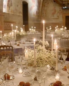 a table with candles and flowers on it in a fancy setting for an event or wedding