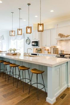 a kitchen island with four stools next to it