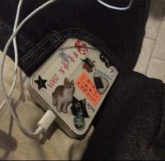 a cat is sitting on the back of someone's jeans with an ipod charger attached to it