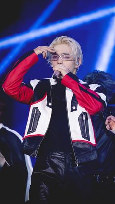 a man with white hair and glasses on stage