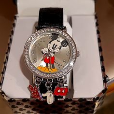 a watch with a mickey mouse face on it's display stand in a box