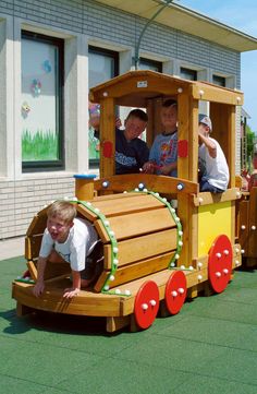 two children are playing in a wooden train