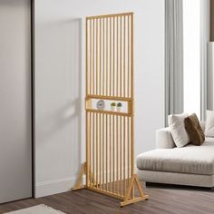 a living room with a white couch and a wooden rack in front of the door