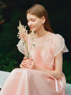 This Daisy See-through Petal Sleeve Lace Dress features a delicate and ethereal design with sheer petal sleeves that add a touch of romantic flair. The dress is adorned with a polka-dot pattern over a soft, pastel pink fabric, enhancing its dreamy aesthetic. Perfect for special occasions, this dress combines elegance with a playful charm, thanks to its lightweight lace and flowy silhouette. - Crafted from fine, see-through lace, this dress provides a subtle hint of allure while maintaining sophistication.- Petal sleeves offer a unique, floral-inspired look, making the dress ideal for spring and summer events.- The polka-dot detailing across the fabric adds a whimsical element to the overall design.- Its cinched waistline and flared skirt create a flattering silhouette that accentuates Tulle Flower Dress, Petal Sleeve Dress, Feminine Summer Dress With Sheer Sleeves, Elegant Spring Dress With Swiss Dot, Elegant Swiss Dot Dress For Spring, Feminine Polka Dot Dress For Brunch, Feminine Swiss Dot Summer Dress, Feminine Swiss Dot Dresses, Sheer Feminine Dress For Spring