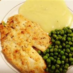 a white plate topped with fish, peas and broccoli