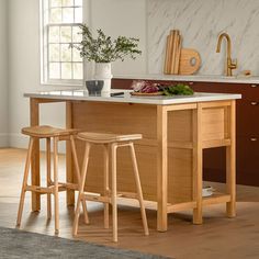 a kitchen island with two stools next to it