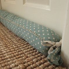 a blue and white polka dot pillow sitting on the floor next to a door way