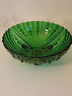 a green glass bowl sitting on top of a table