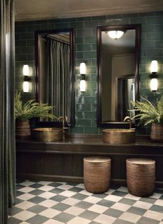 a bathroom with checkered flooring and green tiles on the walls, along with potted plants