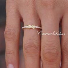 a woman's hand with a gold ring on it and two diamonds in the middle