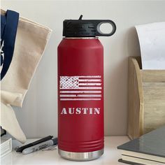 a red water bottle with an american flag on it and the word, austin