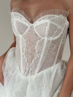 a woman wearing a white corset with sheer lace