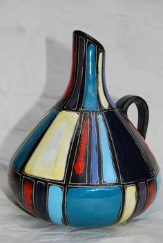 a multicolored vase sitting on top of a white table