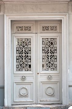 two white doors with ornate designs on the front and side panels, one is open