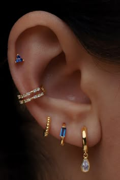 a woman's ear with three different types of piercings