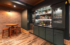 a home bar with wooden floors and brick walls, along with built - in shelving