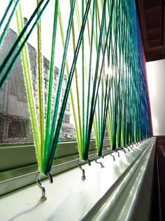 green and blue lines are on the side of a window sill in front of a building