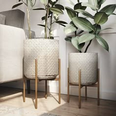 two planters sitting next to each other in front of a white couch and chair