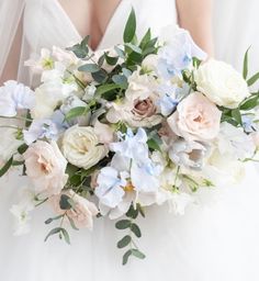 a bridal holding a bouquet of white and blue flowers