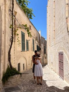 two people are standing in an alleyway and one is holding the other's head