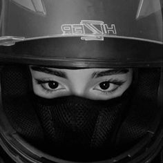 a woman wearing a motorcycle helmet with her eyes wide open