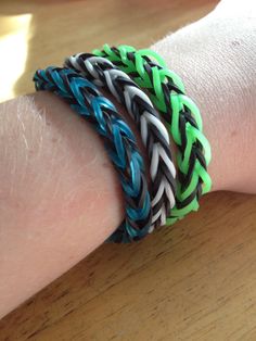 a person's arm with two different colored bracelets on it, one is black and the other is green